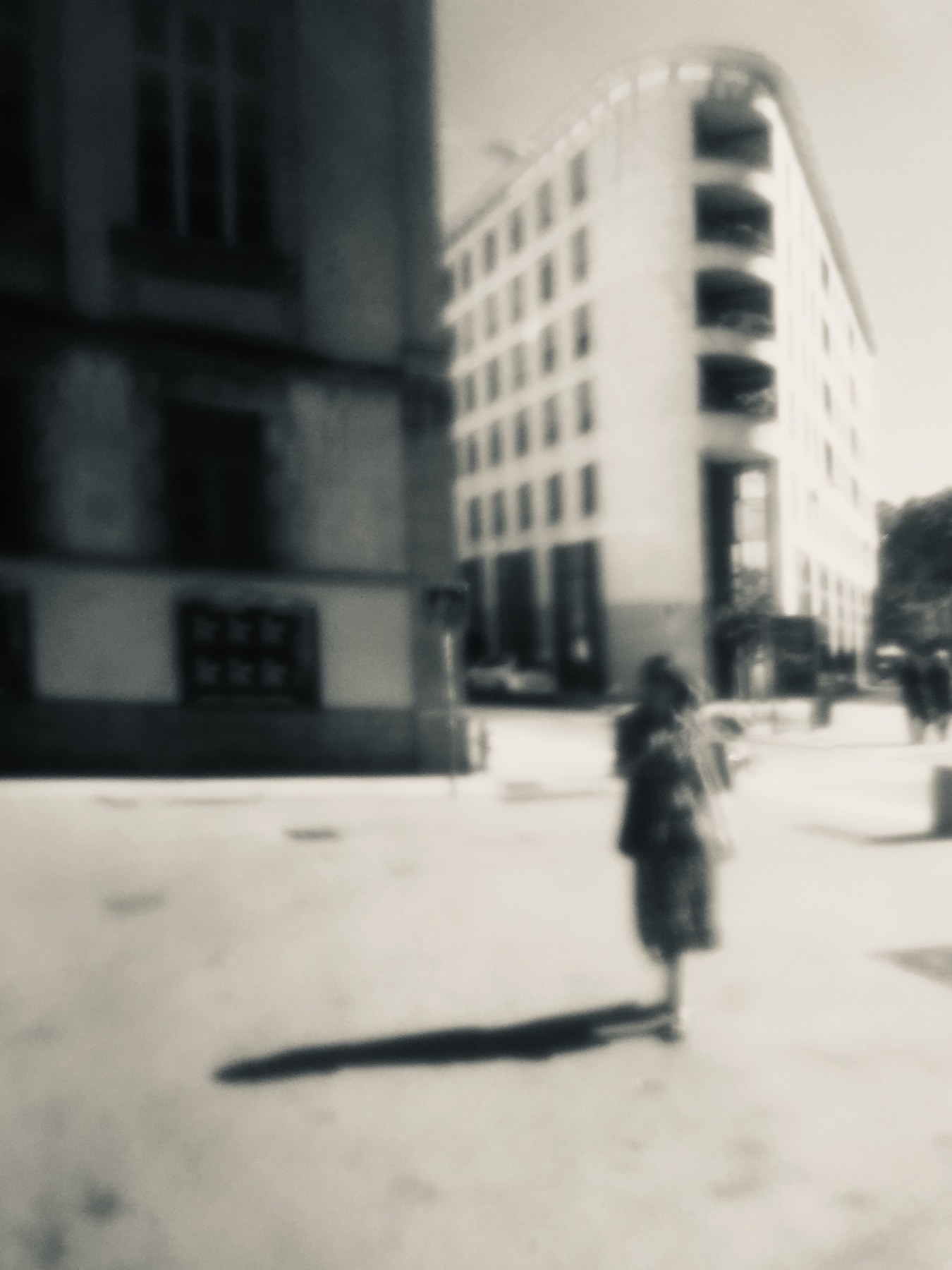 Une silhouette et son ombre devant les façades de Lyon